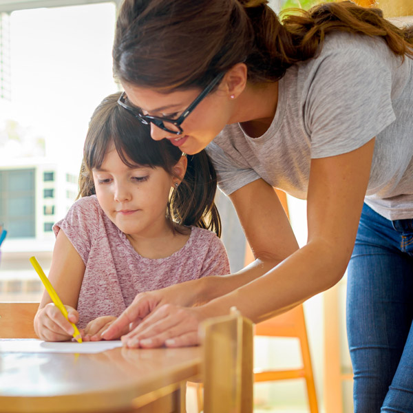 girl getting help with her writing from teacher